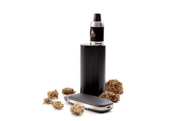 CBD and THC vaping products, dry herb vaporizer and healthy inhaling of cannabis concept theme with e cigarette and vape mod surrounded by marijuana buds isolated on white background CBD and THC vaping products, dry herb vaporizer and healthy inhaling of cannabis concept theme with e cigarette and vape mod surrounded by marijuana buds isolated on white background cbd vape stock pictures, royalty-free photos & images